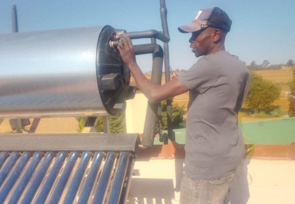 Technician installing a new geyser on a rooftop in Sandton